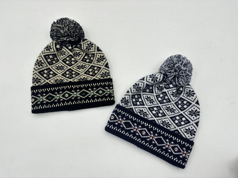 Deux bonnets à pompon jacquard motif flocon nordique noir-crème et marine-blanc sur fond blanc style ski