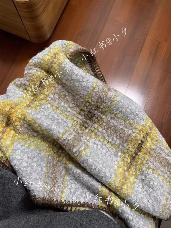 Plaid épais bouclette motif carreaux gris moutarde beige plié sur chaise parquet bois ambiance cosy