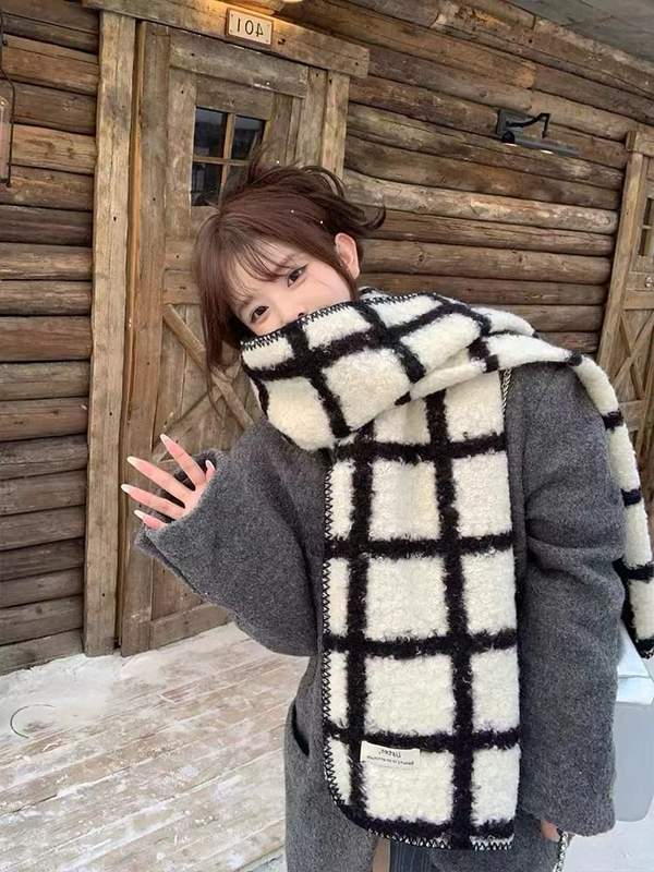 Écharpe à damier noir et blanc en laine sherpa moelleuse portée sur manteau gris