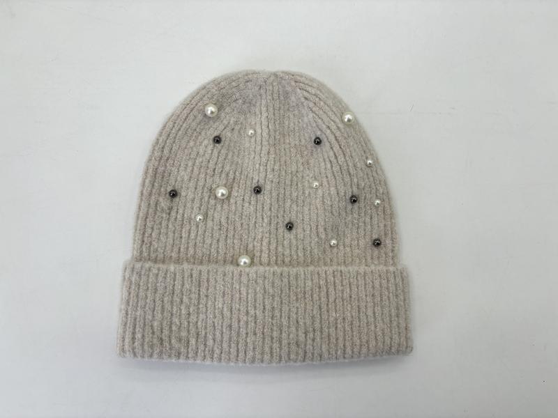 Bonnet côtelé beige à plat avec perles blanches et cristaux hématite dispersés sur fond blanc - bonnet hiver élégant