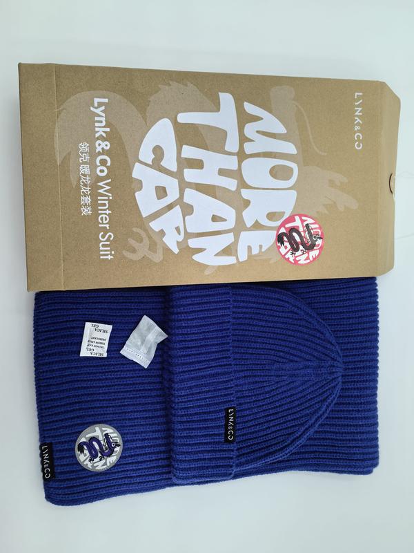 Ensemble bonnet et écharpe côtelé bleu roi à plat à côté d'une boîte cadeau kraft