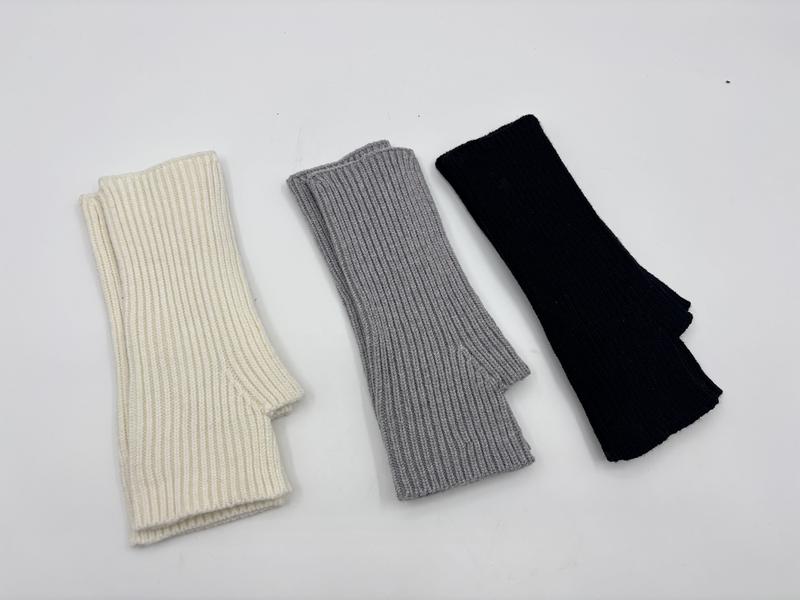 Trois paires de mitaines tricot côtelé sans doigts posées à plat