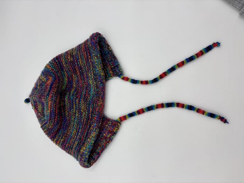 Bonnet bébé fait-main en laine multicolore rayée avec cache-oreilles et brides tressées
