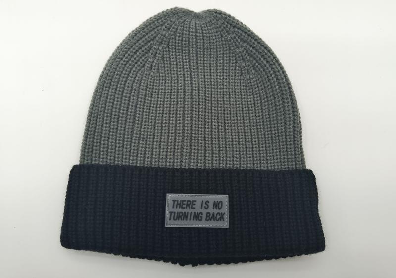 Bonnet hivernal côtelé bicolore gris et noir avec patch caoutchouc slogan There Is No Turning Back sur revers foncé