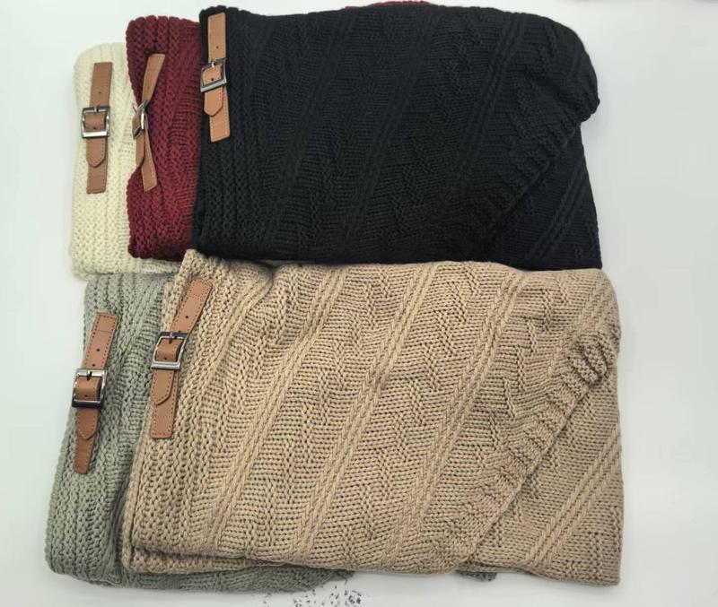 Cinq plaids pliés en grosse maille torsadée beige gris noir bordeaux crème avec sangles cuir marron - cadeaux hiver cosy