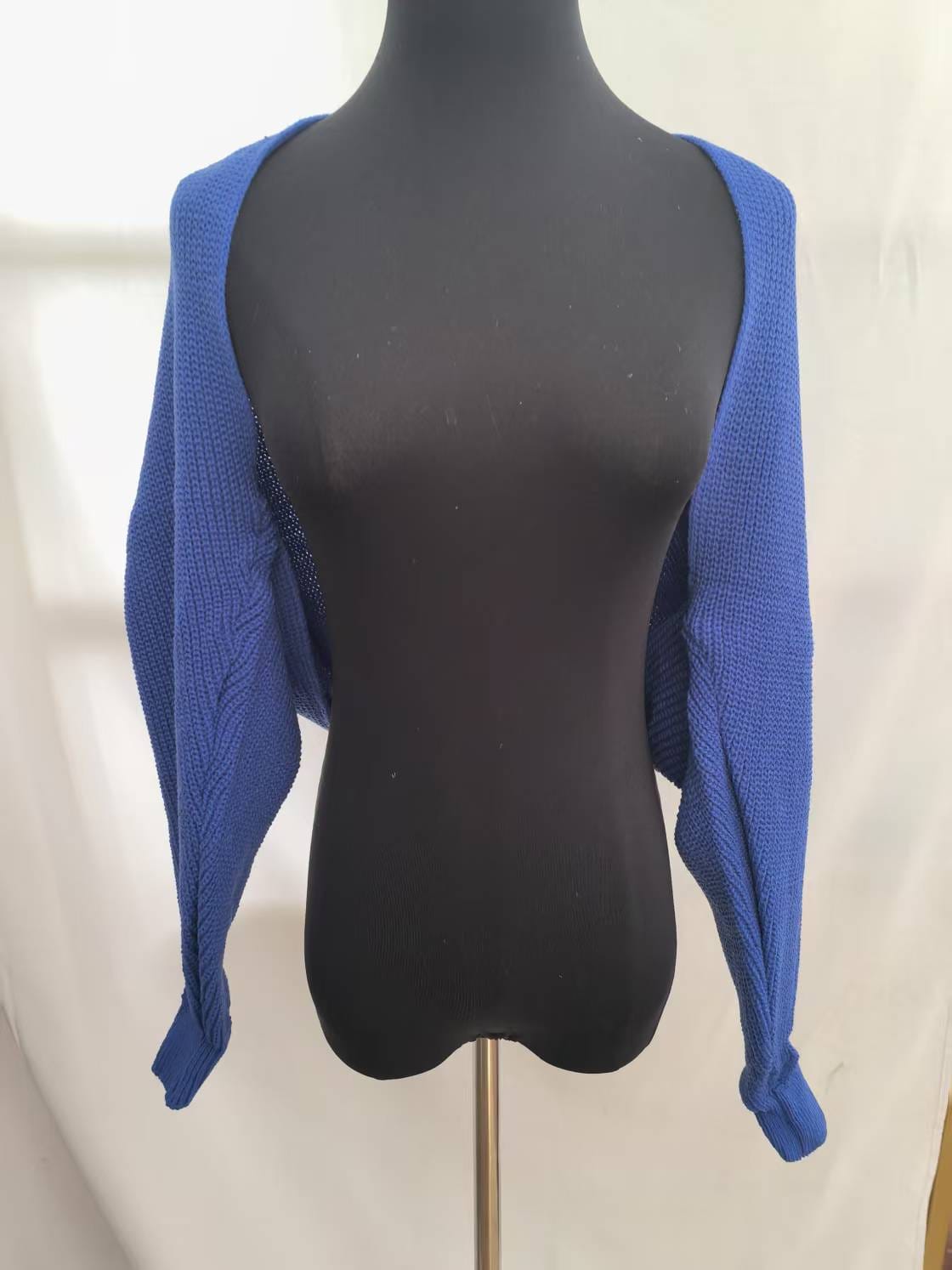 Boléro shrug court bleu roi en grosse maille manches longues ouvert sur mannequin robe noire - look coloré tendance