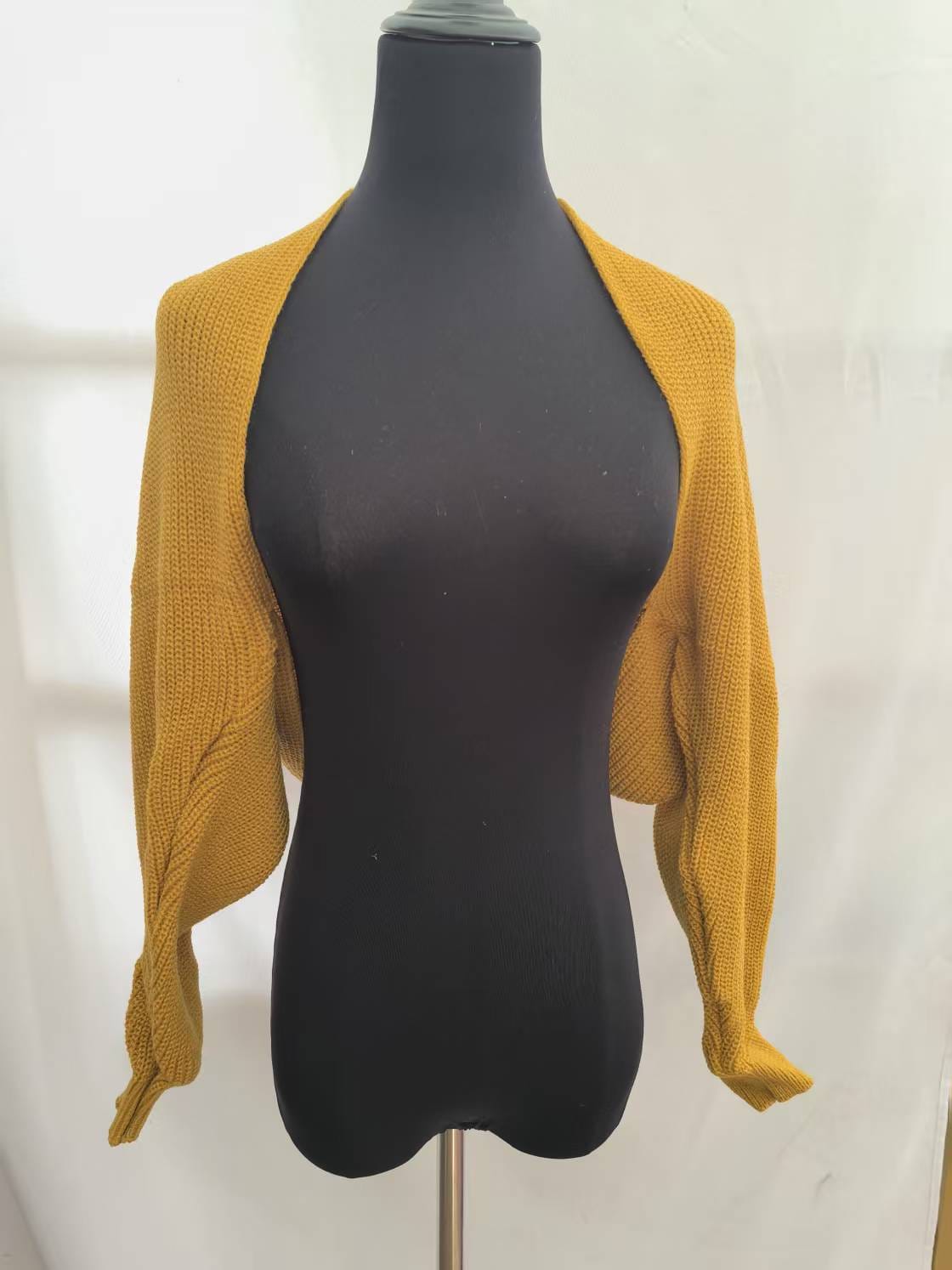 Boléro shrug court jaune moutarde en grosse maille manches longues ouvert devant sur mannequin - look automne tendance