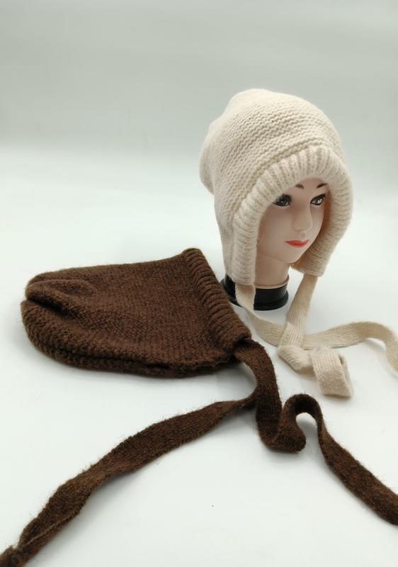 Bonnet tricoté crème avec cache-oreilles et liens longs sur mannequin