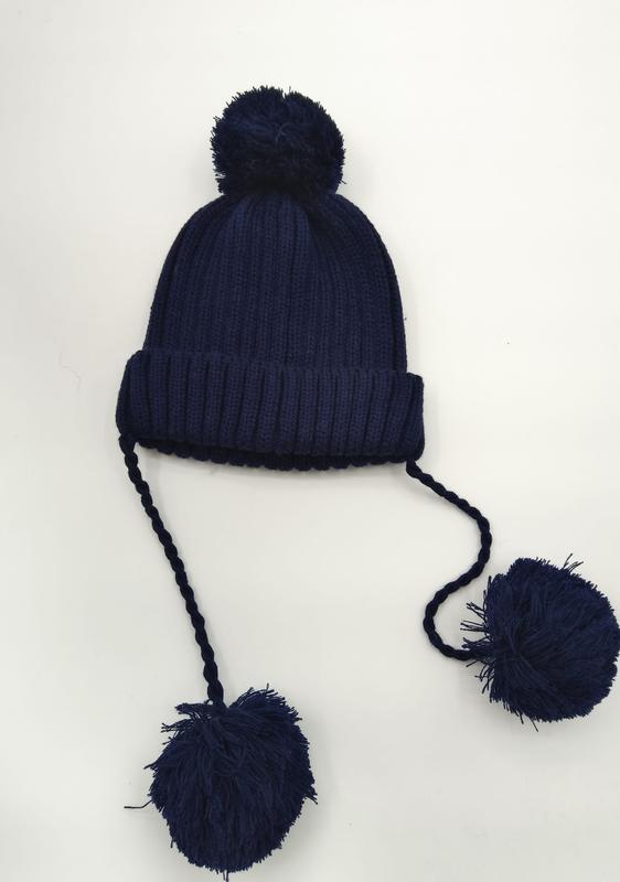 Bonnet d'hiver bleu marine côtelé avec pompon au sommet et deux longues tresses terminées par des pompons