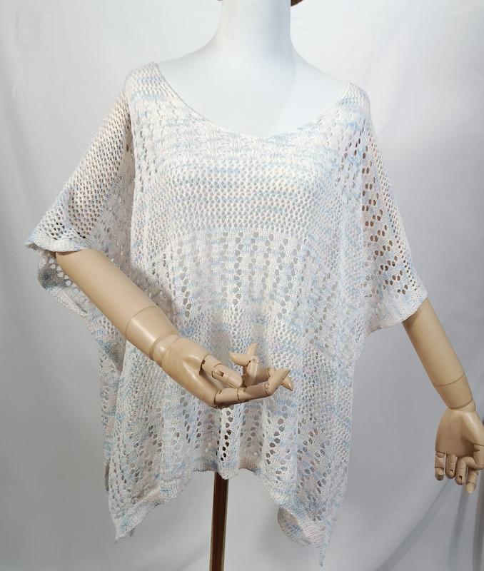Poncho top crochet ajouré blanc et bleu multicolore à manches courtes semi-transparent sur mannequin