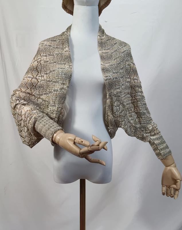 Boléro shrug maille dentelle ouvert devant coloris beige et gris chiné sur mannequin aux mains en bois articulées