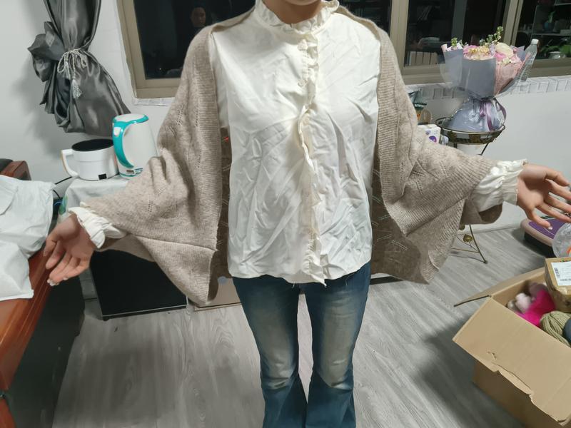 Femme en cardigan oversize beige sur chemise matelassée crème à col volants et jean évasé