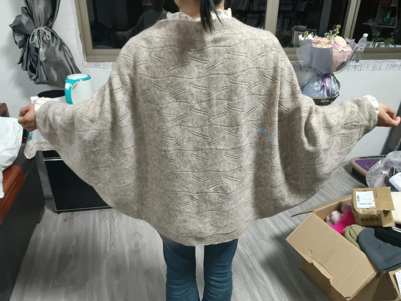 Femme de dos portant un pull oversize beige manches chauve-souris avec motif pointelle losanges
