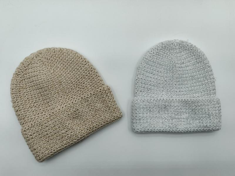 Deux bonnets tricot épais texturé côte à côte: beige sans revers et gris clair avec revers replié