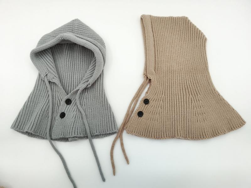 Deux cache-cous à capuche tricotés côtelés en gris et beige avec boutons noirs et cordons
