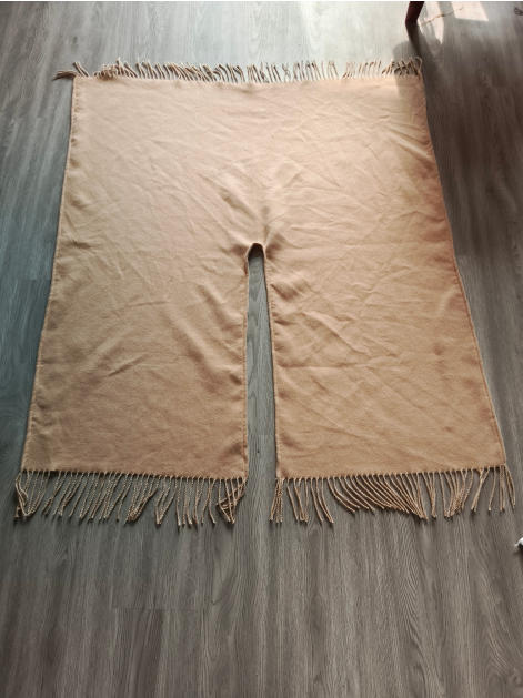 Poncho tissé beige à plat avec fente centrale et franges torsadées sur bords