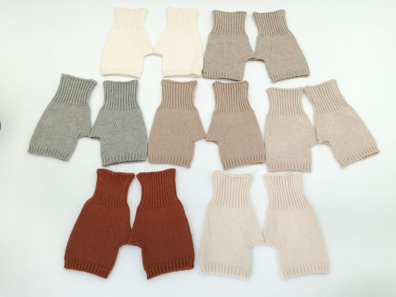 Sept paires de bloomers bébé tricotés main posés à plat