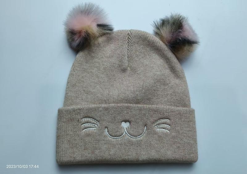 Bonnet bébé fille en maille beige avec deux oreilles de chat en fausse fourrure colorée et broderie visage chat