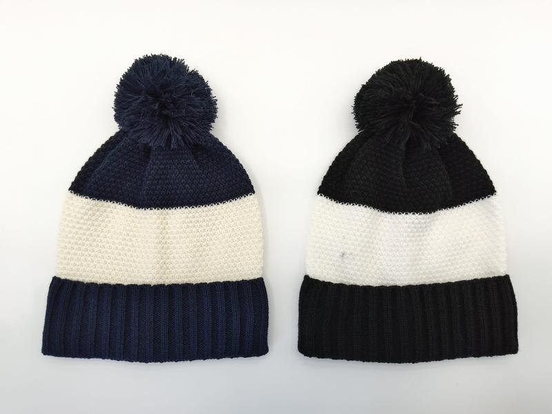 Deux bonnets pompon tricot côte côte à côte : rayures marine et crème à gauche