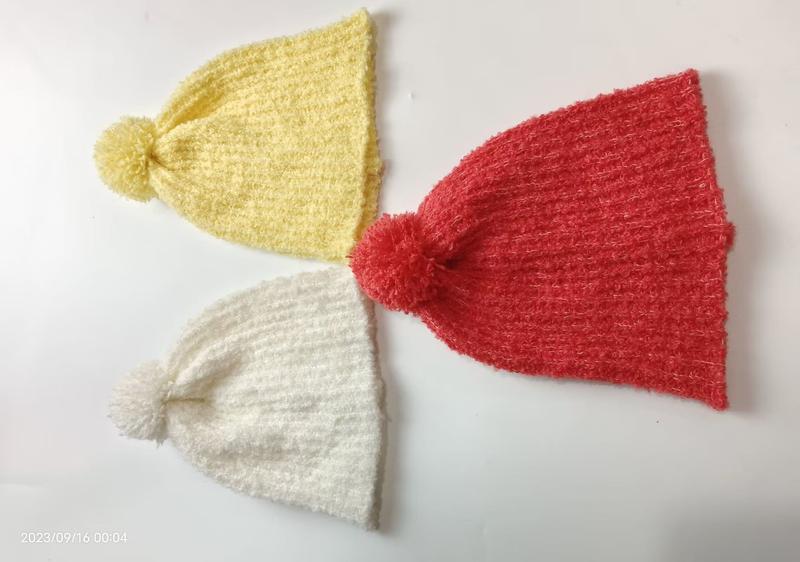 Bonnets tricot pompon à plat sur fond blanc