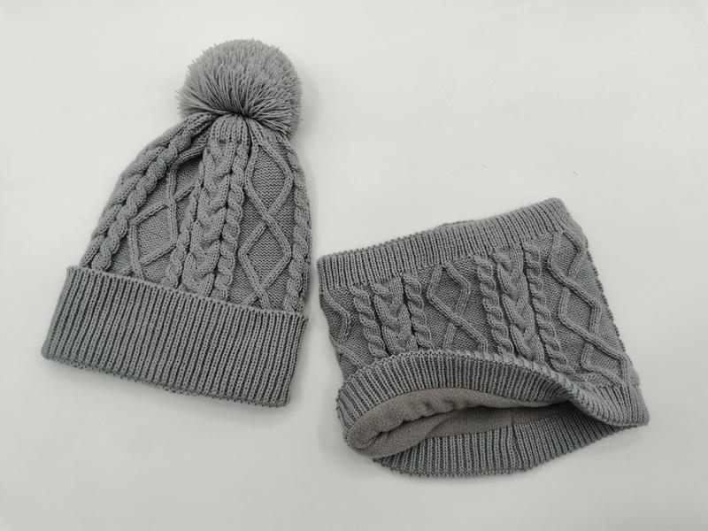 Bonnet gris en maille torsadée avec pompon et tour de cou assorti en polaire doublée