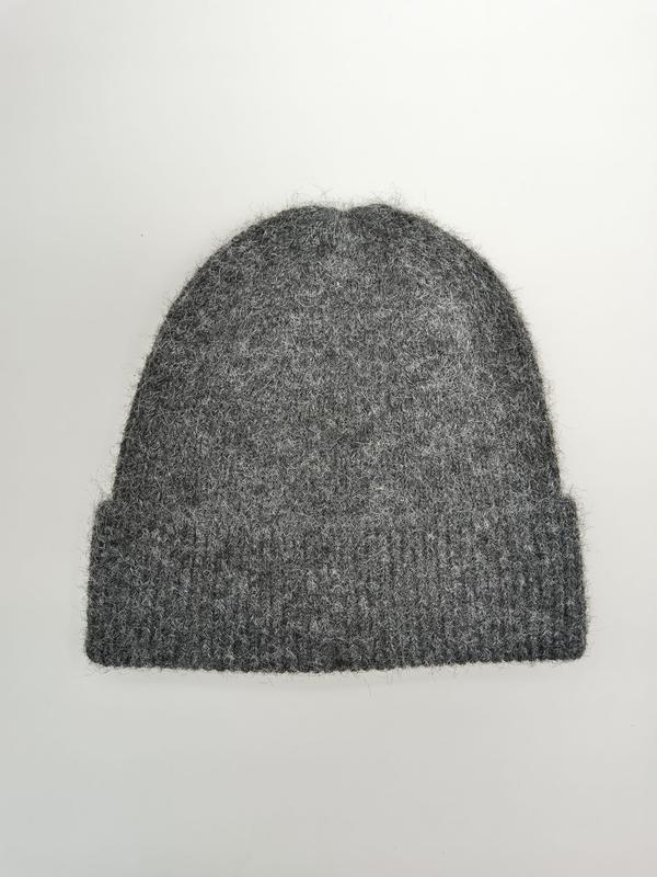 Bonnet hiver gris moelleux à revers côtelé posé à plat sur fond blanc