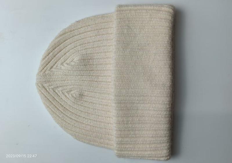 Bonnet côtelé crème replié à plat sur fond blanc