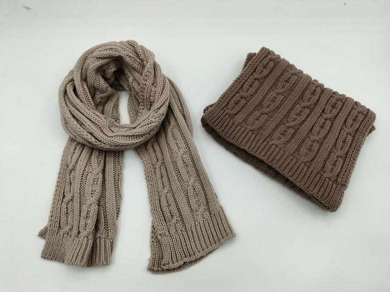 Écharpe torsadée beige et snood marron plié sur fond blanc
