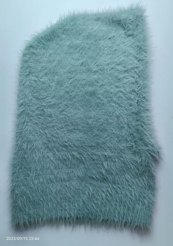 Échantillon tissu fausse fourrure tricot vert menthe à longs poils sur fond blanc