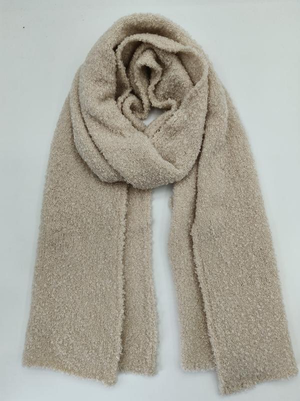 Grande écharpe beige en laine bouclette oversize drapée et posée à plat fond blanc