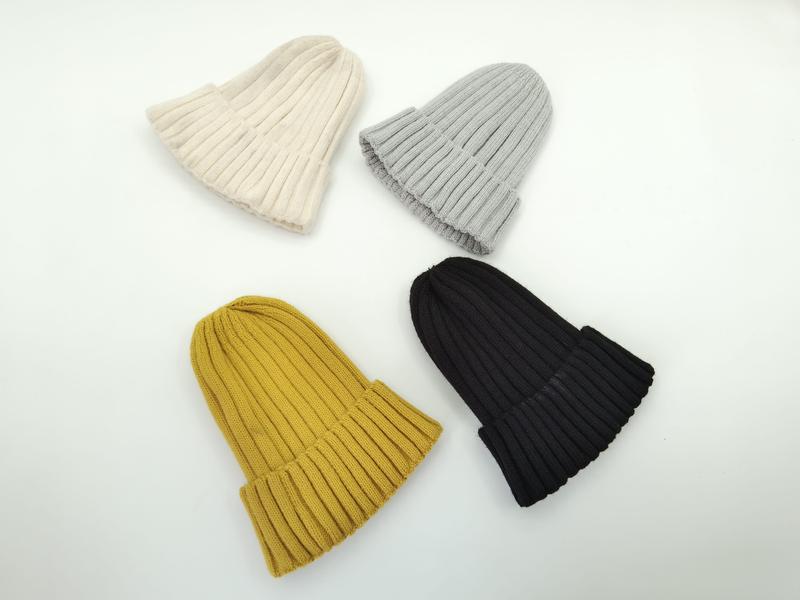 quatre bonnets côtelés posés à plat en crème