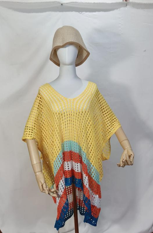 Mannequin en poncho crochet ajouré jaune avec rayures multicolores bas de vêtement teal orange blanc bleu et bob beige