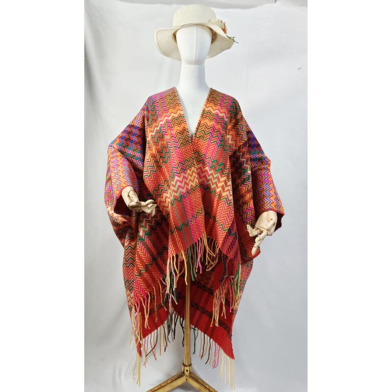 Mannequin blanc portant un poncho châle chevron multicolore à franges et chapeau bord large