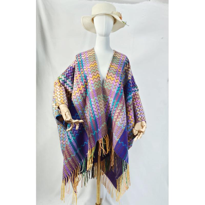 Mannequin portant un poncho cape tissé chevron multicolore à longues franges et chapeau bord large