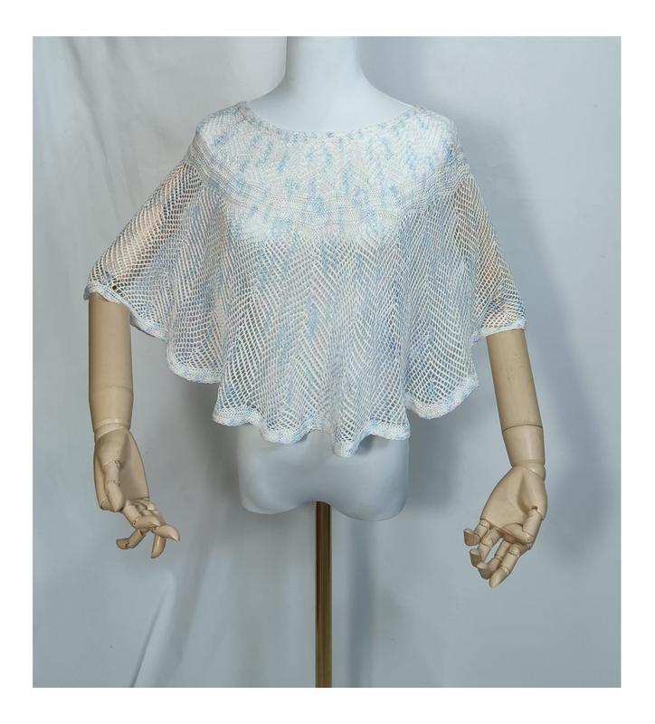 Cape poncho crochet filet blanc et bleu ciel sur mannequin aux bras en bois
