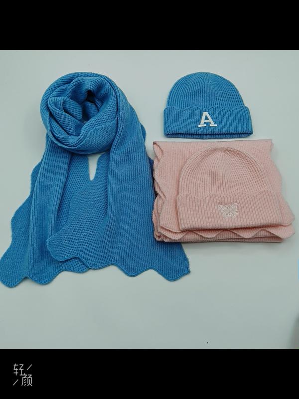 Ensemble écharpe et bonnet tricot bleu brodé lettre A et set rose avec détail papillon posés sur fond blanc