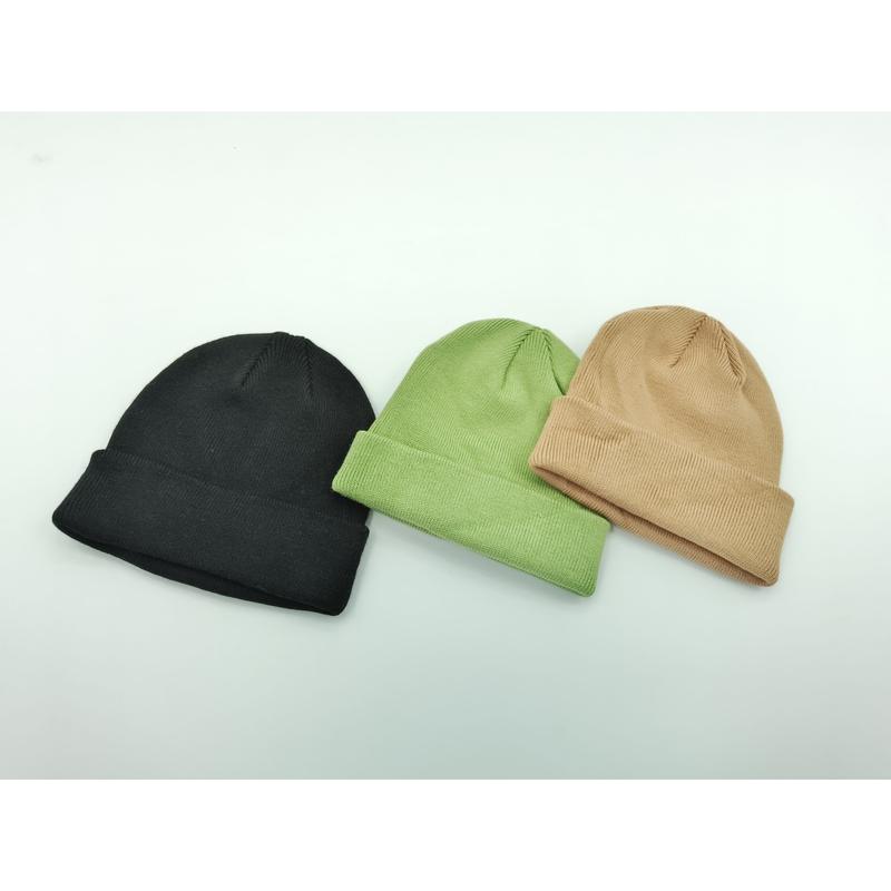 Trois bonnets à revers tricotés posés à plat en noir