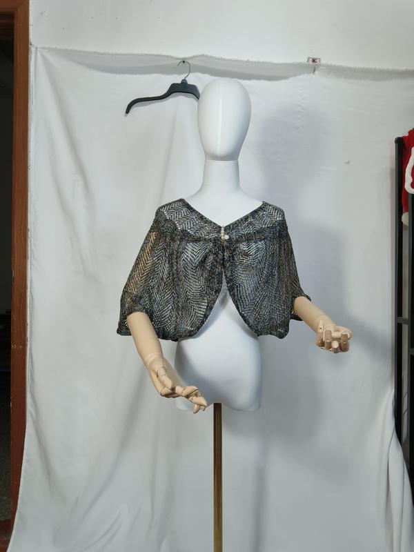 Capelet châle en tricot ajouré métallisé bleu et or sur mannequin blanc avec fermeture bouton nacre