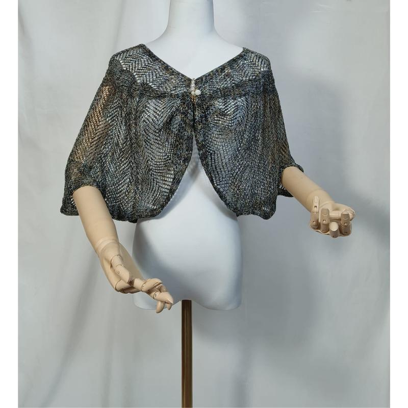 Boléro capelet dentelle tricotée bleu gris métallisé sur mannequin blanc aux mains en bois