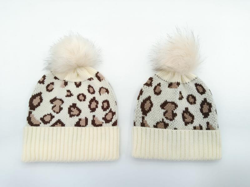 Deux bonnets crème ivoire imprimé léopard avec pompons en fausse fourrure
