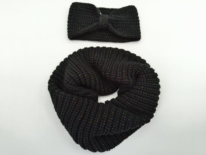 Snood tubulaire noir en grosse maille posé à côté d'un bandeau torsadé noir avec fils métalliques multicolores lurex