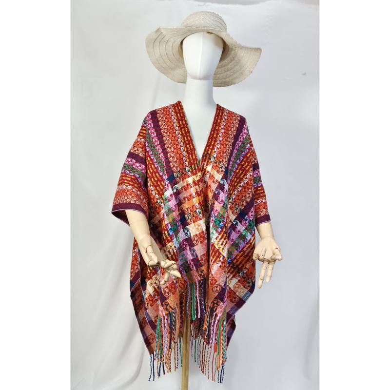 Poncho ouvert multicolore à motif géométrique tissé main avec frange colorée sur mannequin et chapeau bords larges