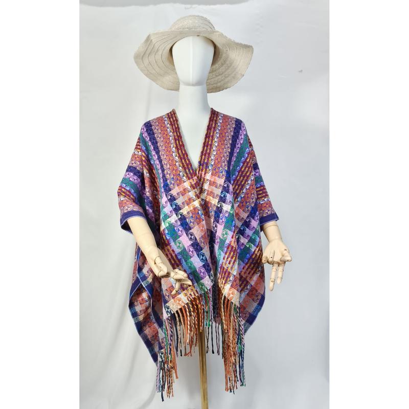Mannequin portant un poncho tissé multicolore à motif géométrique avec frange et chapeau de paille fond blanc
