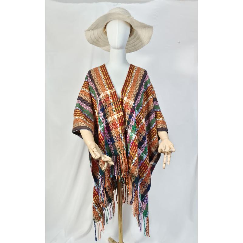 Mannequin portant un poncho tissé main à motif diamant géométrique multicolore avec frange et chapeau large bord fond blanc