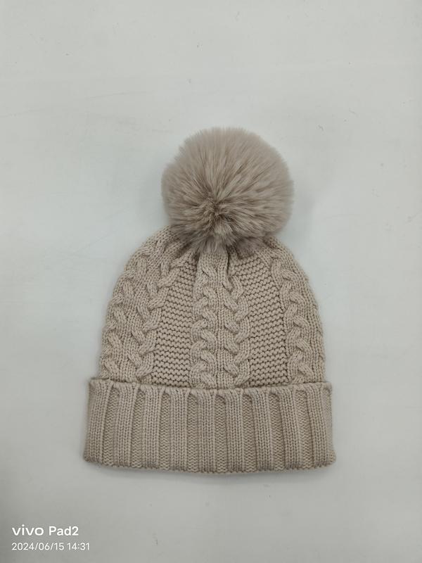 Bonnet en maille torsadée beige avec grand pompon fausse fourrure et revers côtelé
