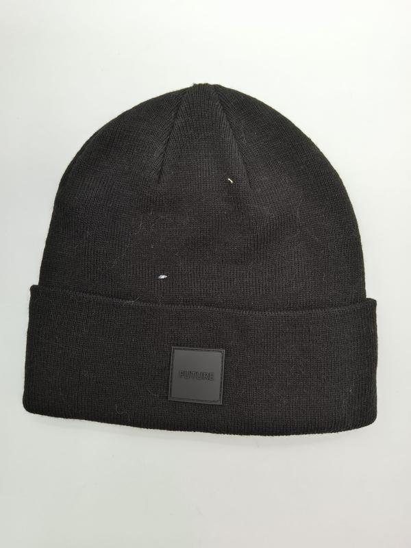 Bonnet en maille côtelée noire avec grand revers et étiquette patch caoutchouc FUTURE sur fond blanc