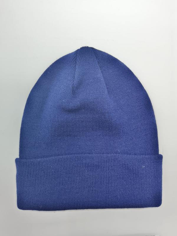 Bonnet tricot bleu roi à revers côtelé posé à plat sur fond blanc