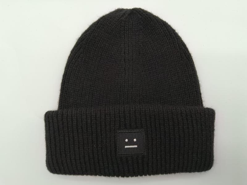 Bonnet maille côtelée noire avec revers replié et patch brodé visage