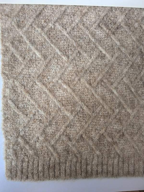 Gros plan couverture plaid tricotée beige motif losange treillis en mélange laine avec bordure côtelée – plaid canapé neutre et cosy