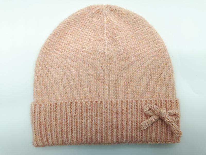 Bonnet tricot rose pêche chiné avec revers côtelé replié et nœud décoratif tricoté
